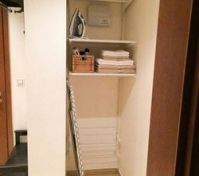 Storage closet with towels and iron