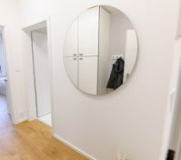 Hallway with round mirror and storage